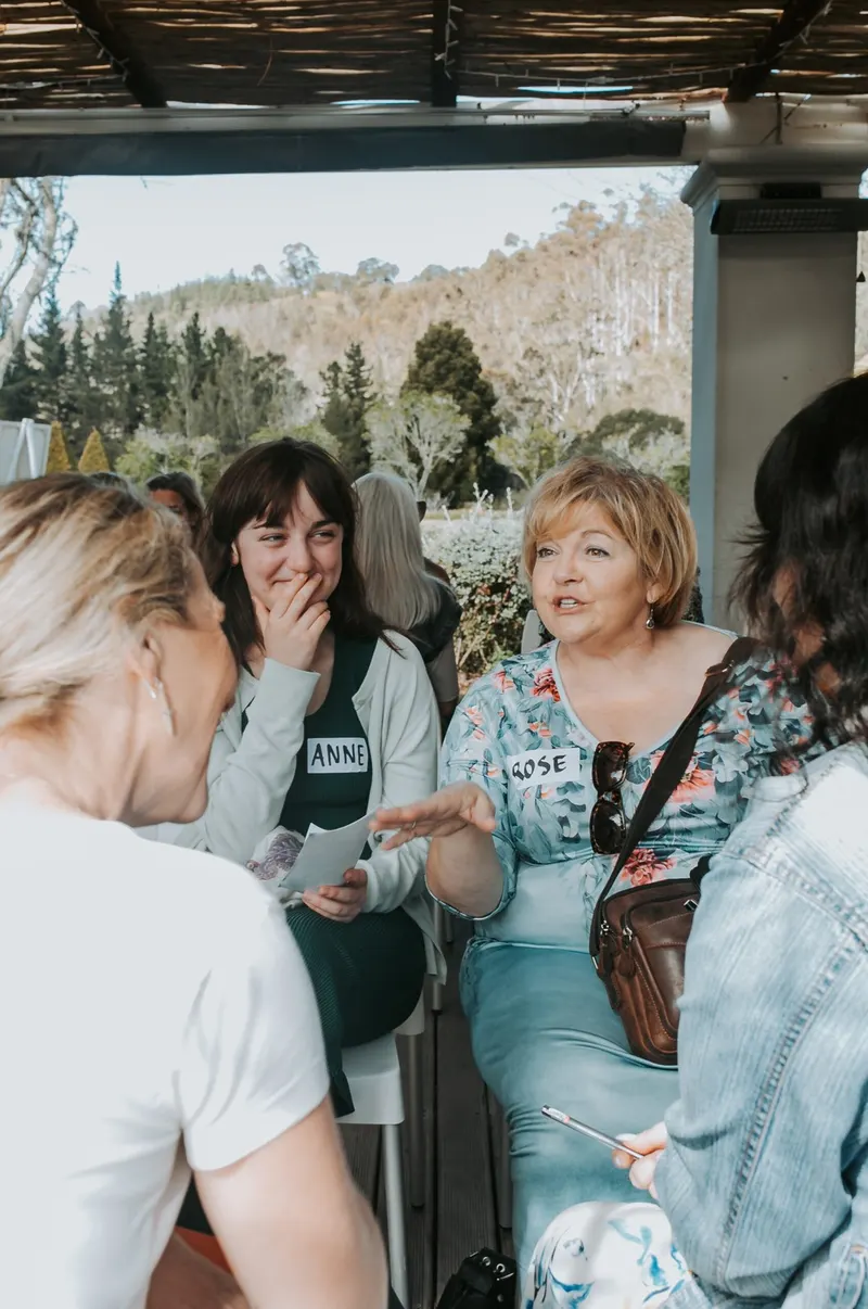 Members laughing at a table, August 2025