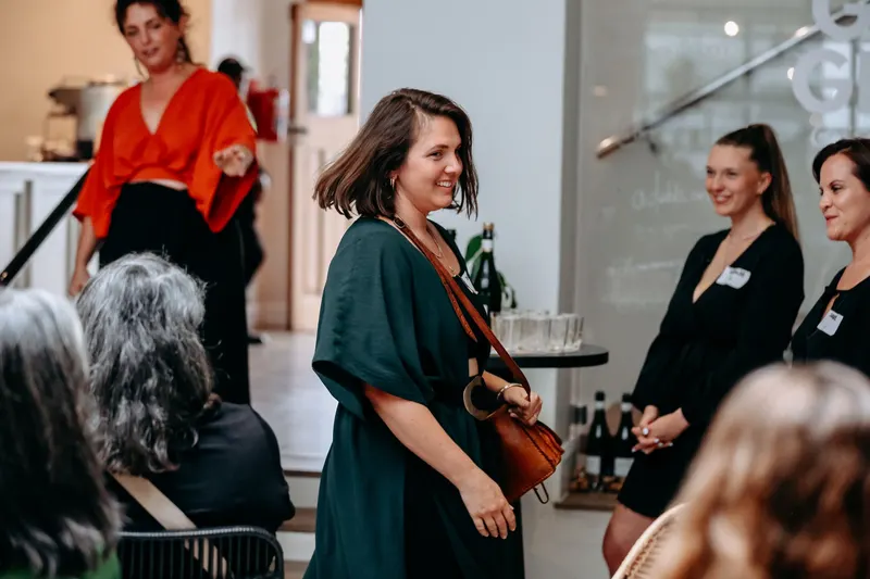 Women standing together and laughing, February 2025