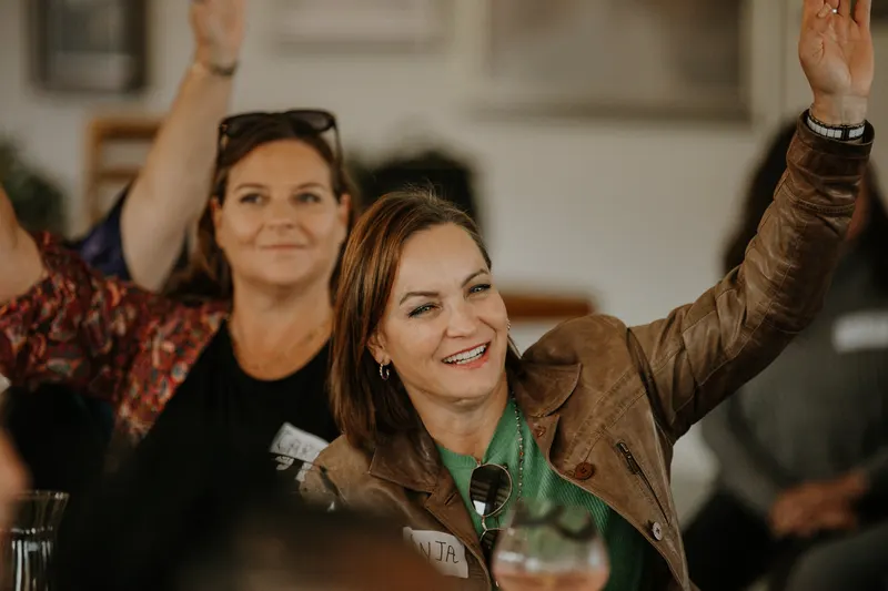 Two members, one with her hand up, during the talks