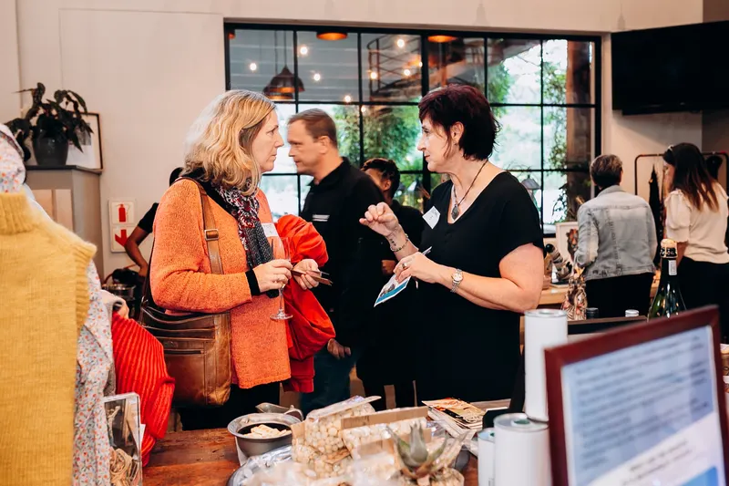 Women talking at an expo table, Barrington’s