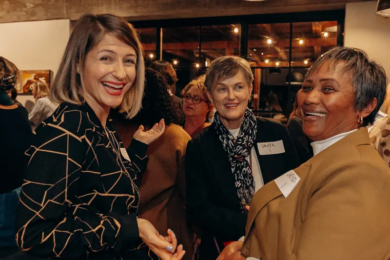 Three women laughing together, May 2025